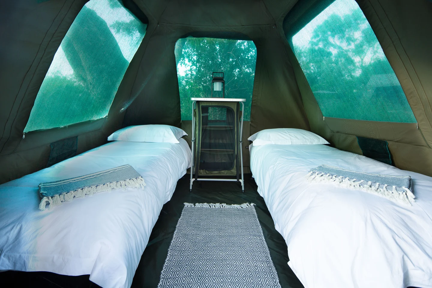 Twin stretcher beds made up with linen inside a Timbavati canvas dome tent